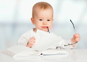 funny baby with glasses reading a book